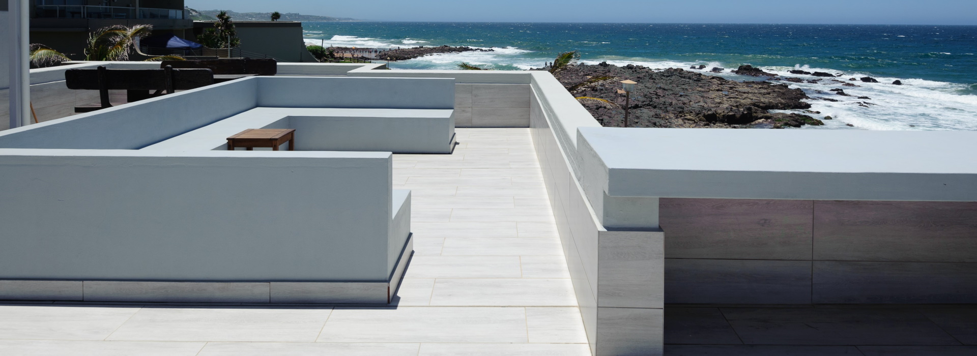 White rooftop terrace looking over the rocky Chaka's Rock coastline and the Indian Ocean